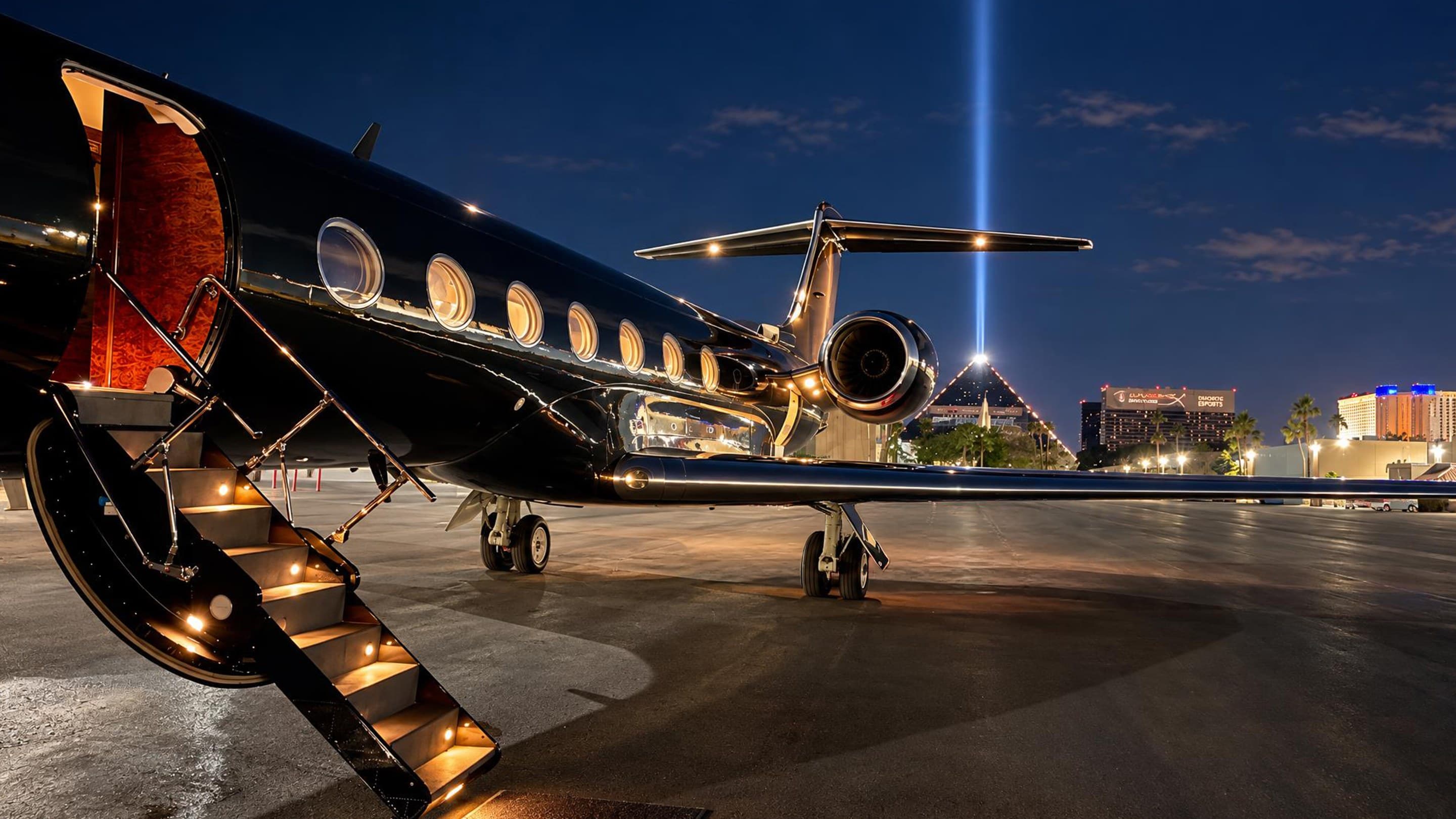 Glossy black private aircraft with illuminated stairs on a Las Vegas ramp at night